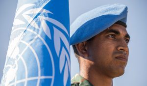 FN-soldat och FN-flagga