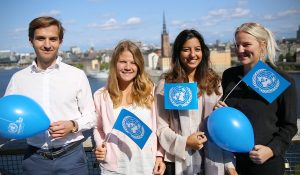 Ambassadörer viftar med FN-flaggor och ballonger