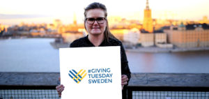 Petra Hallebrant håller upp en skylt för Giving Tuesday
