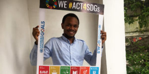 Goodluck Minja i Tanzania håller upp skylt för globala målen