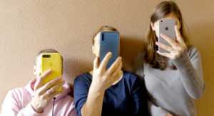 Tre georgiska ungdomar med mobiltelefoner.