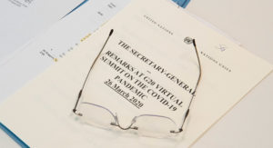 Antonio Guterres glasögon vilar på en rapport om covid 19. Foto: UN Photo/Evan Schneider