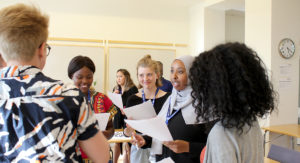 Glada ungdomar löser en uppgift på en ungdomskonferens om FN