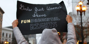 En skylt hålls upp under en protest med texten "Girls just wanna have FUNdamental human rights"