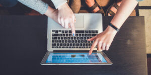 Tre personer pekar på en dataskärm. Foto: Schnobrich/Unsplash