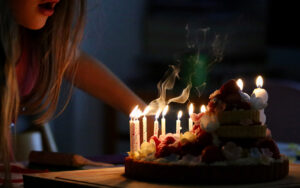 Barn blåser ut ljus på tårta