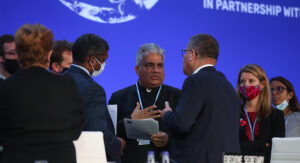 Indiens klimat- och miljöminister står i en klunga och förhandlar med COP-ordföranden Alok Sharma.