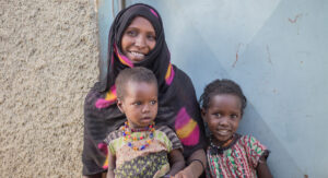 Etiopisk mamma med två barn. Mamman och ett av barnen tittar in i kameran. Andra barnet tittar åt sidan.