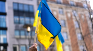 En hand håller upp Ukrainas flagga i luften.