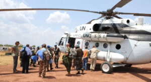 FN-arbetare framför en helikopter i en insats i syd Sudan.