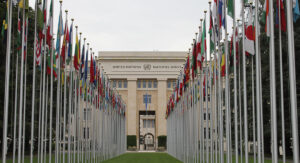 Bild på FN-kontoret i Genève med flaggor i fonden.